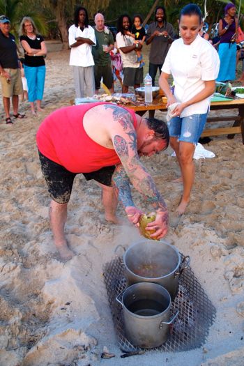 Chef Joseph DeSimone adds some fresh coconut water to a Lionfish stew as chef Paula Da Silva looks on