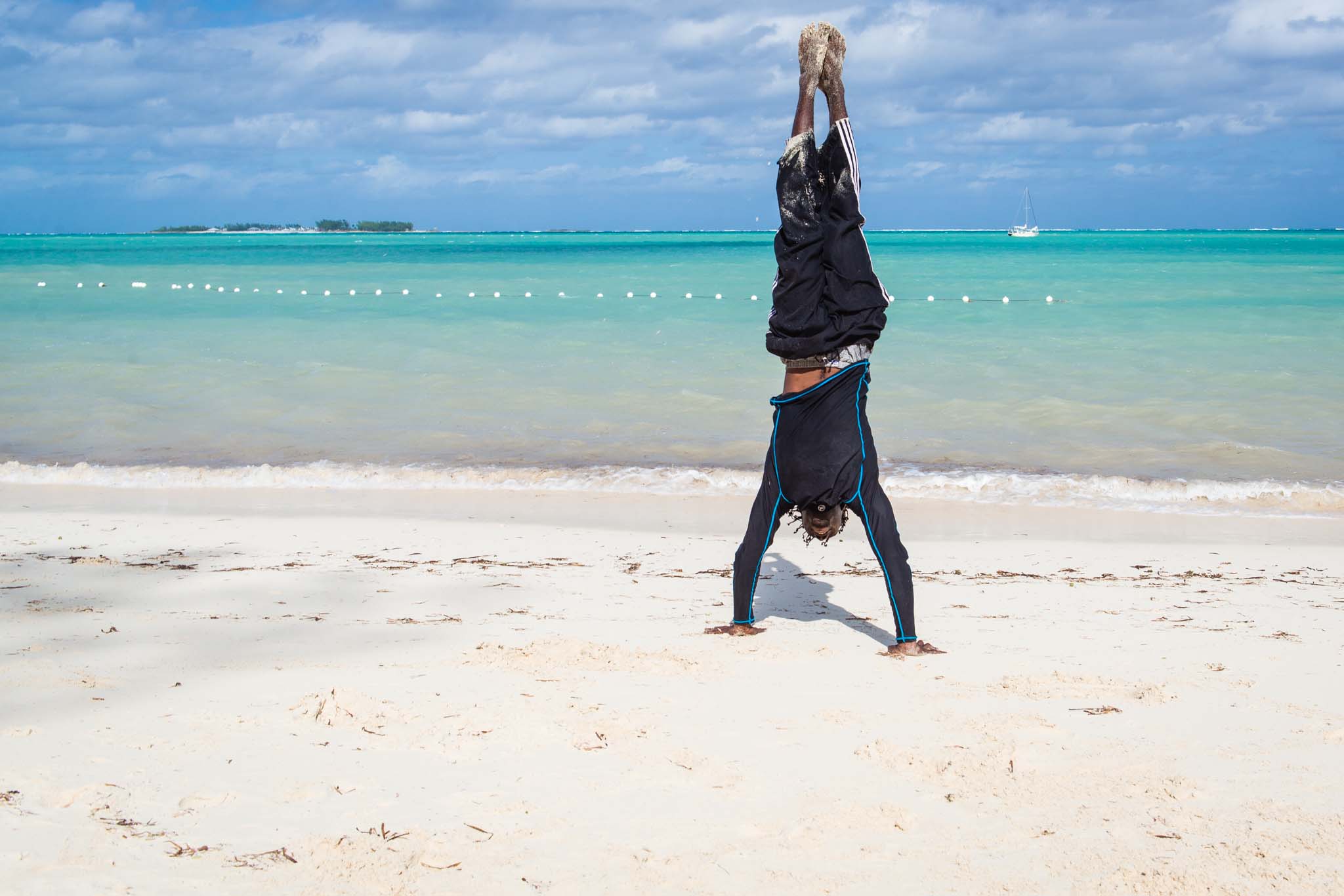 Lucien of PappaSurf handstand on Cable Beach, Nassau by Patrick Bennett