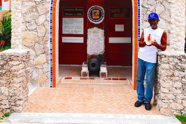Bahamian artist Ashley Saunders outside his masterwork, Dolphin House in North Bimini | Credit: Zickie Allgrove