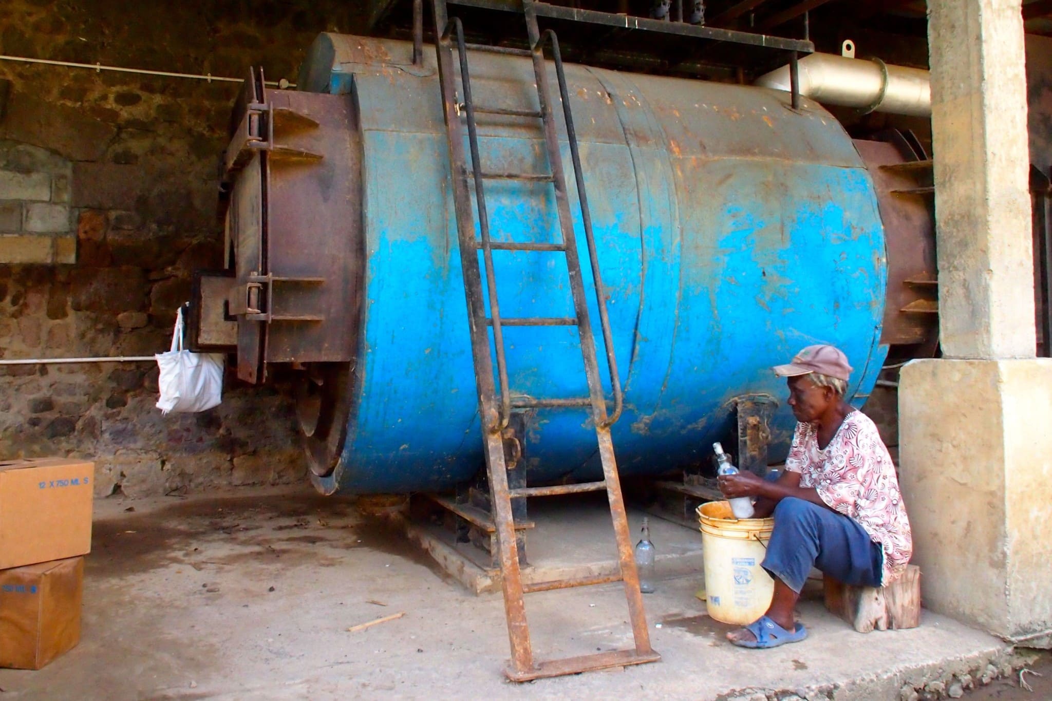 Washing bottles by hand at the Macoucherie Distillery, Dominica | SBPR