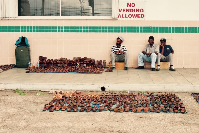 Never mind the sign, the streets beneath The Half-Way-Tree Clock Tower are still among the best places to find great buys on locally-produced Jamaican goods, especially handmade leather sandals like these | SBPR