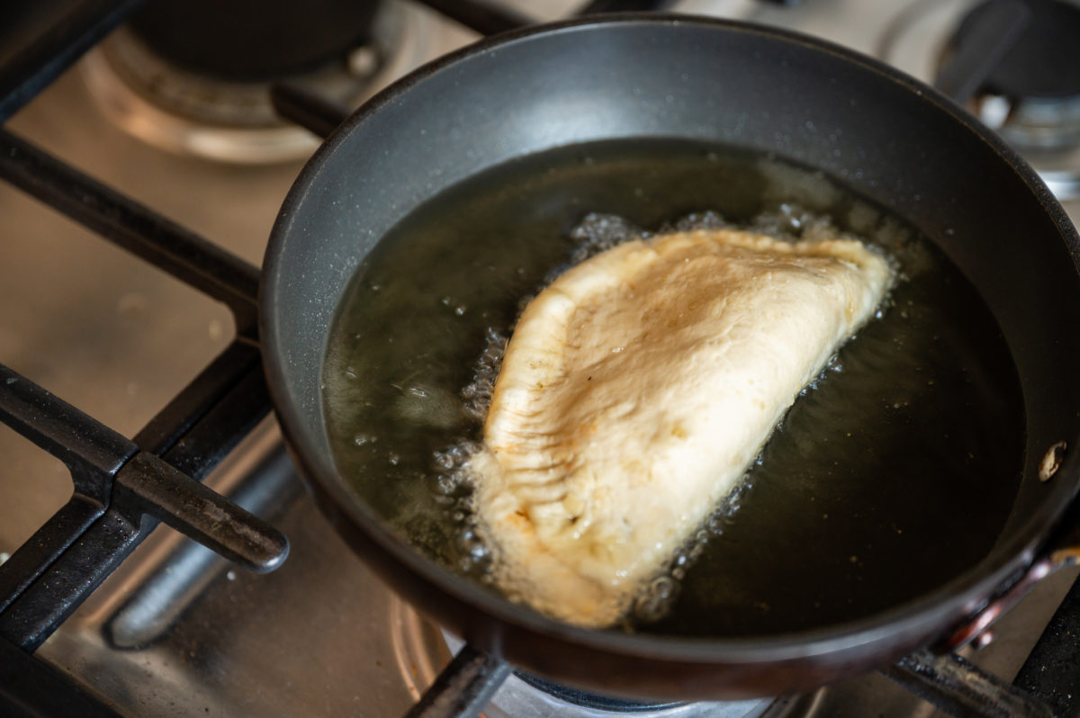 Saltfish pate frying to a golden brown