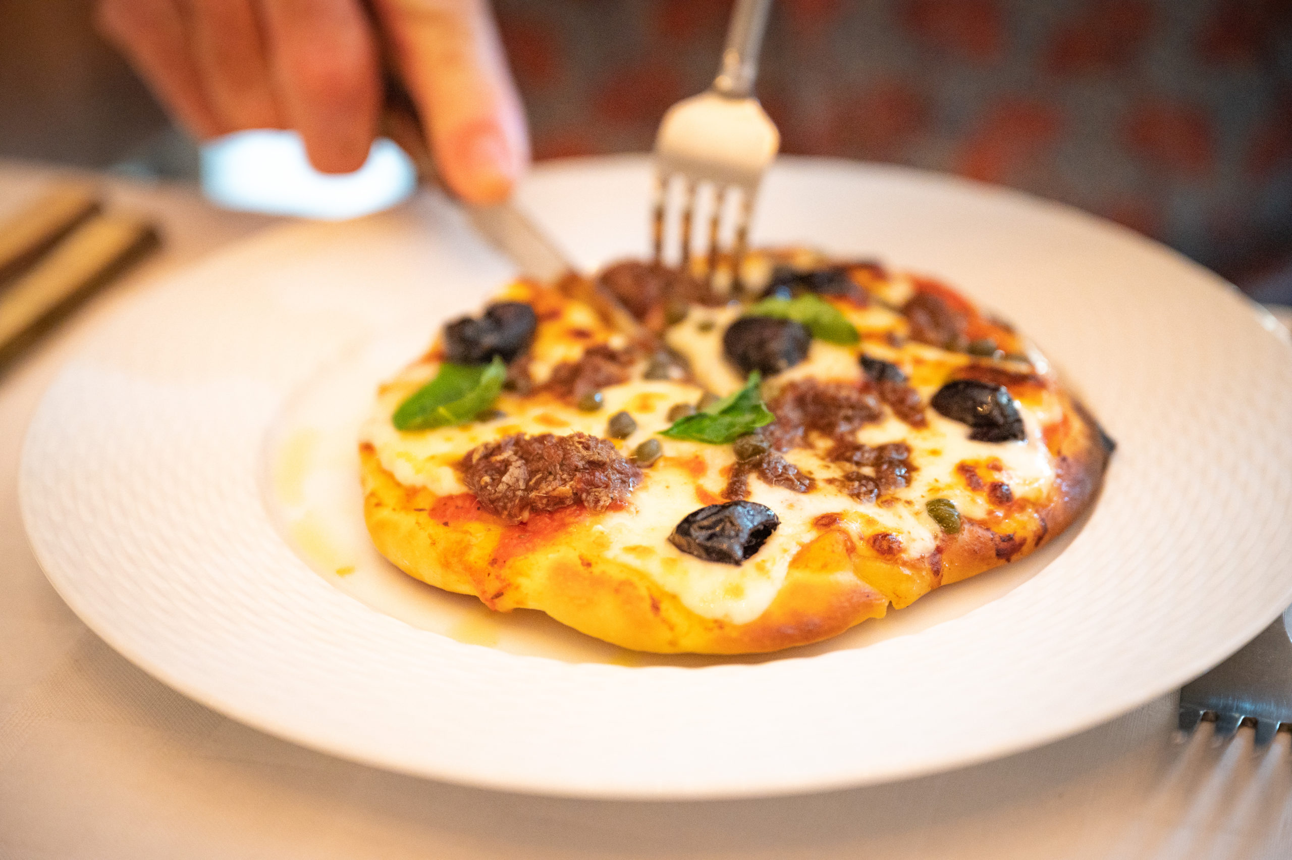 Ziggy's pizzette decorated with anchovies, capers, and black olives